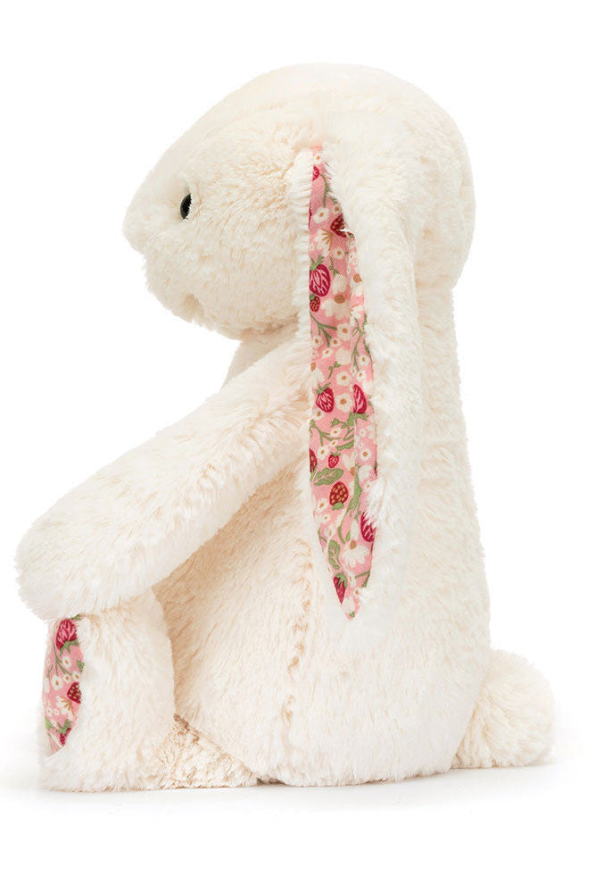 White plush toy with floral scarf on a white background