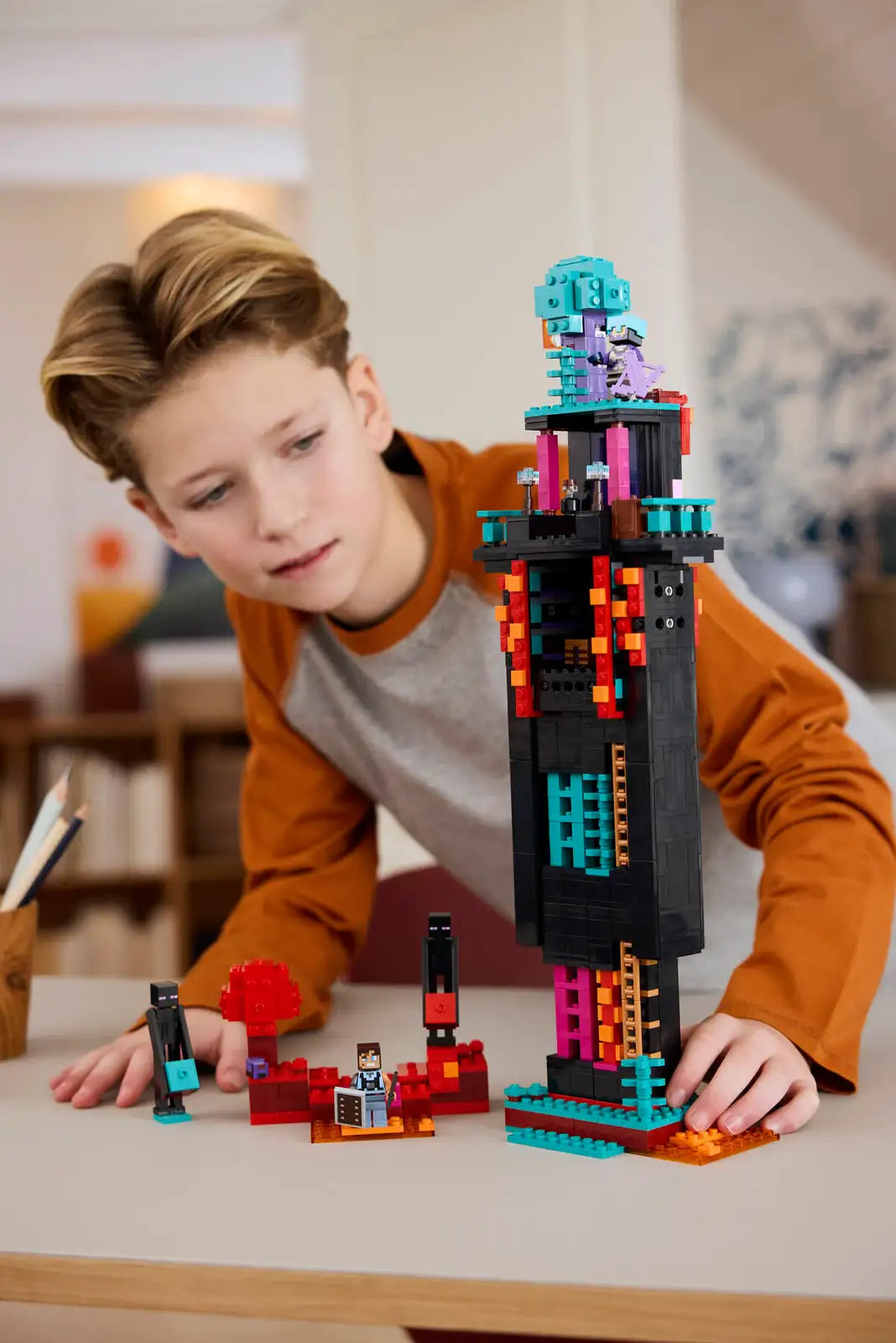 Child playing with a colorful building block set on a table.