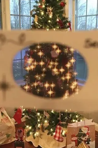 Decorated Christmas tree with lights and ornaments, held up to a window with a snowy view. Looking through 3-D Paper Glasses