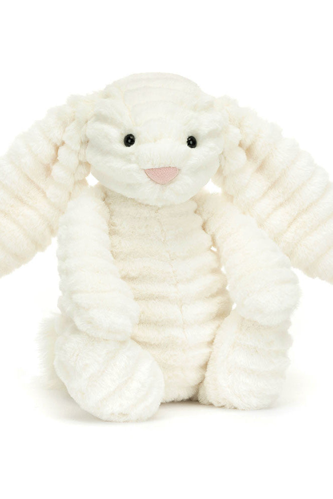 White plush bunny toy on a white background black eyes pink nose ribbed texture