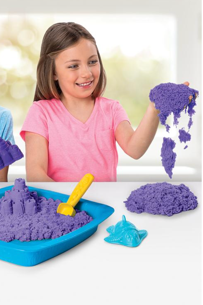 Two kids playing with kinetic sand in a blue box 