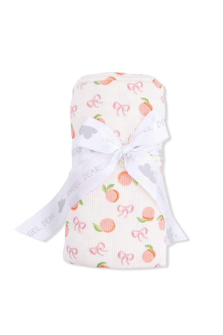 Baby blanket with peach and bow pattern on a white background